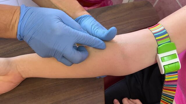 aboratory in clinic. Female lab assistant taking venous blood for test. Take blood from a vein for analysis