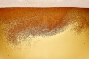 Close-up of golden beer being poured from tap into chilled glass. Drink golden color with thick,...