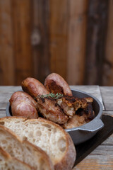Traditional asado criollo plate. Closeup view of chorizos, pork sausages, grilled sweetbreads, potatoes, and bread.