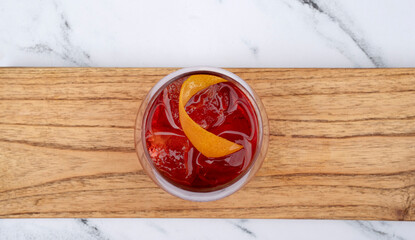 Drinks. Top view of a Negroni cocktail with gin, campari, red vermouth, ice and orange peel in a...