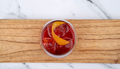 Drinks. Top view of a Negroni cocktail with gin, campari, red vermouth, ice and orange peel in a glass.	
