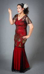 Woman in red sequined flapper dress posing looking to the side