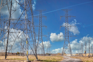 A number of hydro electricity towers or pylons carrying high power lines into the distance, blue...