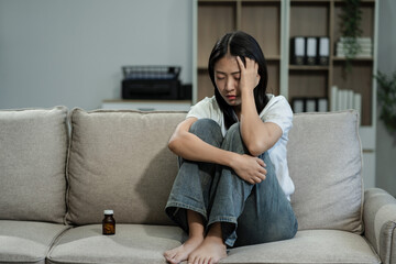 Sad and depressed young female sitting on the sofa, sad mood, feel tired, lonely and unhappy concept.