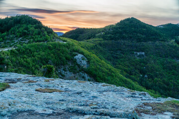 mountain landscape with green grass hills and sunset