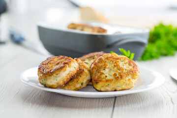 fried meat cutlets in a ceramic form on a wooden table