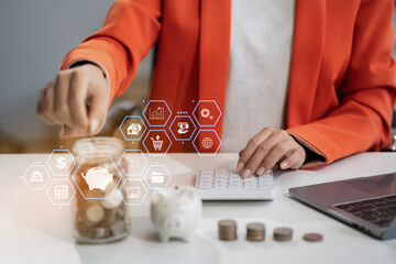 Woman sitting at desk managing expenses, calculating expenses, paying bills using laptop online,...