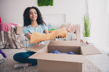 Full size photo of nice young woman hands hold put clothes stuff box package apartment indoors