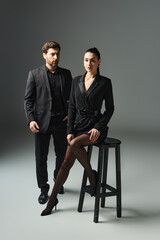 A stylish couple sitting on a stool, exuding love and grace.