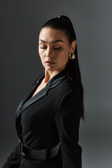 A woman in a black dress with her eyes closed.