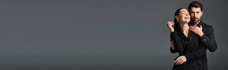 A man and a woman in elegant attire standing together.