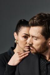 A man and a woman in stylish attire strike a pose together.