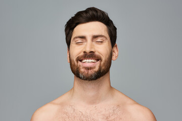 Obraz premium A man with a beard and no shirt is smiling.