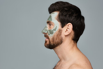 A man wearing a face mask and looking away.