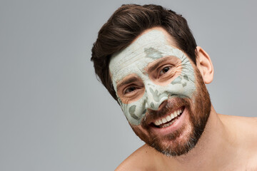 A man wearing a face mask and smiling.