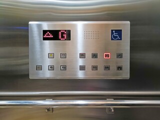 Elevator buttons panel for wheelchair users with handrails on the wall