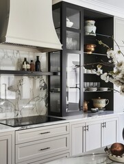 An elegant kitchen with white cabinets, marble countertops, and brass accents showcases luxurious design elements. The focus is on an island with a black texture on a stone countertop, complemented by