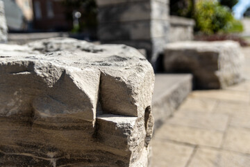 Close-up view - weathered stone bench with intricate textures - blurred background with greenery...