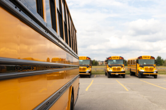 Side view close-up of yellow school bus - parked - sunny day with clouds in sky. Taken in Toronto, Canada.