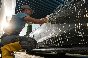 Man Washing Car With Water Spray
