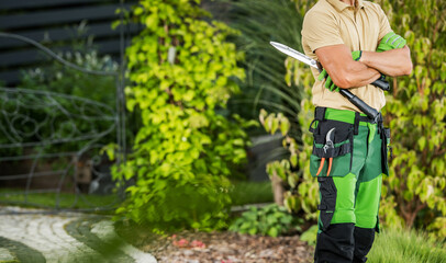 Obraz premium Professional Gardener in Green and Black Uniform Holding Scissors