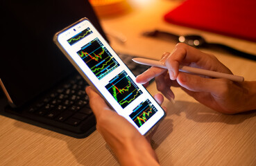businessperson holding and use the mobile phone to check the stock marketing information around the world Highest stock price, listed on the stock exchange