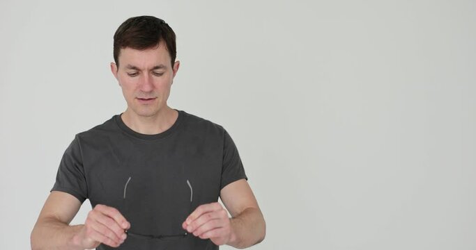 Man putting on glasses with black plastic frames 4k movie slow motion. Vision testing and glasses selection concept