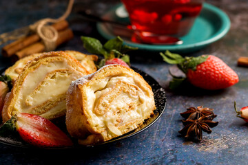 Sliced rolls with custard. The dessert is decorated with fresh strawberries