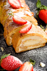 Sliced rolls with custard. The dessert is decorated with fresh strawberries
