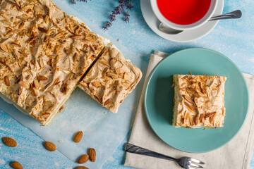 Norwegian cake. With meringue, whipped cream and almonds. Light background