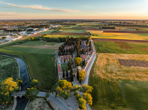 Aerial view of green farmland and river at sunset, San Clemente, Cuenca, Spain.