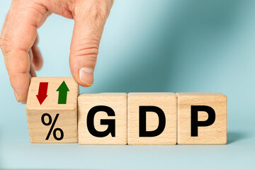 Gross domestic product concept.GDP written on wooden blocks, Down arrow symbol icon. monetary...