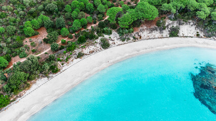 Aerial drone view of person walking on Plage de Palombaggia, Mediterranean beach, island of Corsica, France.