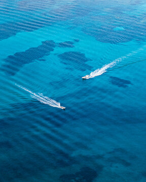 Aerial drone view of two speed boats crossing paths in the Mediterranean sea, island of Corsica, France.