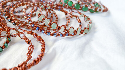 Handmade wire copper bracelet. White background, copy-space.