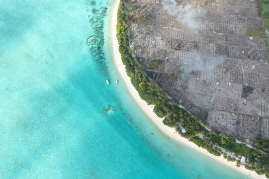 Aerial view of turquoise waters and sandy shores with boats, Thoddoo, Maldives.