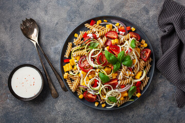 healthy pasta salad with zucchini sweet corn tomato and basil, vegetarian lunch