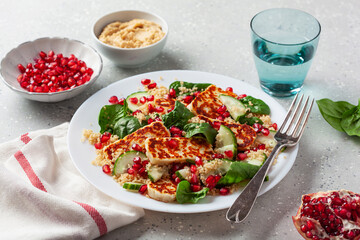 healthy halloumi cheese and couscous salad with cucumber spinach pomegranate hummus