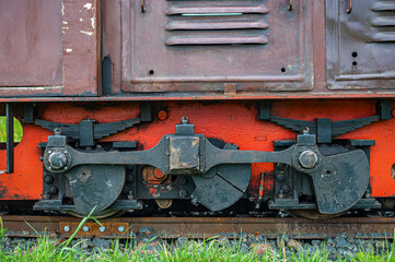 detail of wheels, transmission mechanism and suspensions of an old and small diesel locomotive