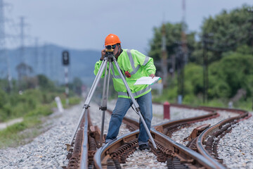 Civil engineer on construction site with survey instrument. work with leveling  camera on railway....