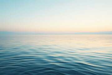 Obraz premium Tranquil Lakeside at Dawn with Gentle Ripples and Clear Sky