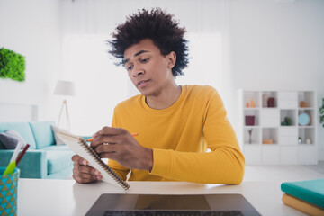 Photo of concentrated man sitting table workplace working writing plan notes room indoors