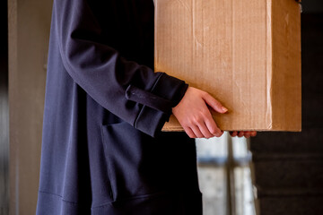 Arabic muslim woman holding carton boxes in her hand