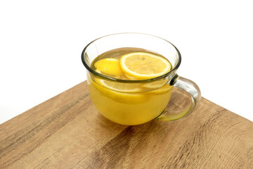 cup of water with honey and lemon slices, isolated white background, wood table