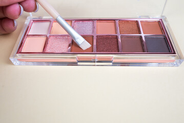 Close up a palette with colorful eye shadows and a makeup brush. Decorative women's cosmetics....