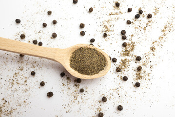  spoon with ground black pepper and peppercorns on a white background