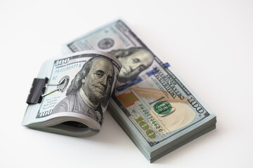 100 dollar banknotes with binder clip on dollars background