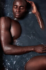 Black man, water and bath for relax or beauty with eyes closed, detox and muscular in hot tub. Male...