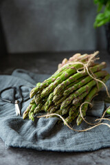 Bunch of fresh green asparagus on the table on the dark background 
