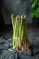 Bunch of fresh green asparagus on the table on the dark background 